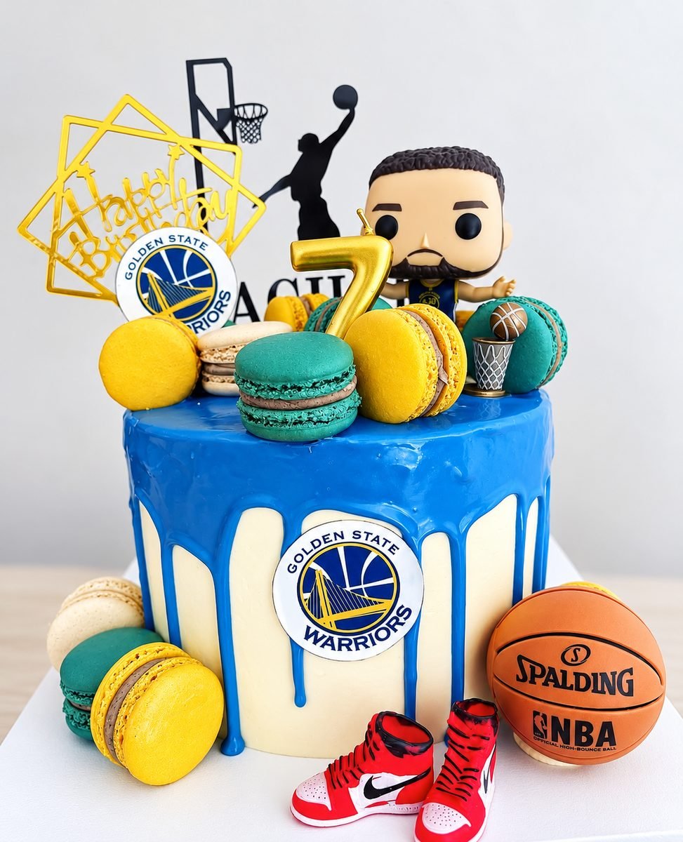 Blue drip birthday cake with Golden State Warriors emblems, teal and yellow macarons, a fondant basketball and sneakers, and a player figurine