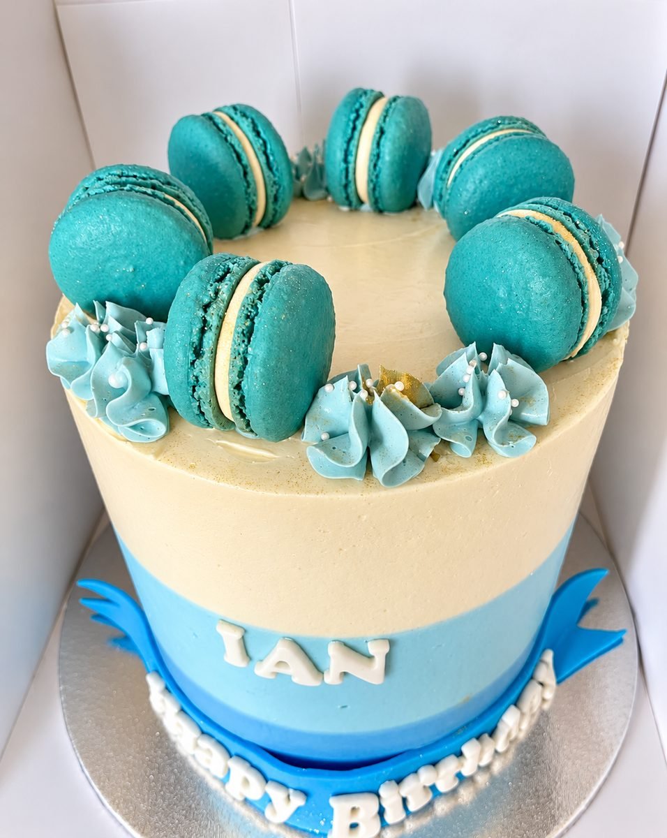 Teal and cream birthday cake crowned with a ring of matching teal macarons